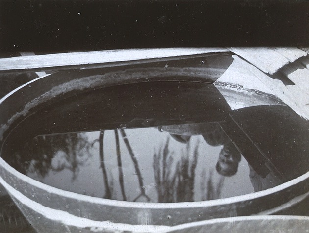 Large tub of gold fish with reflection of Chinaman