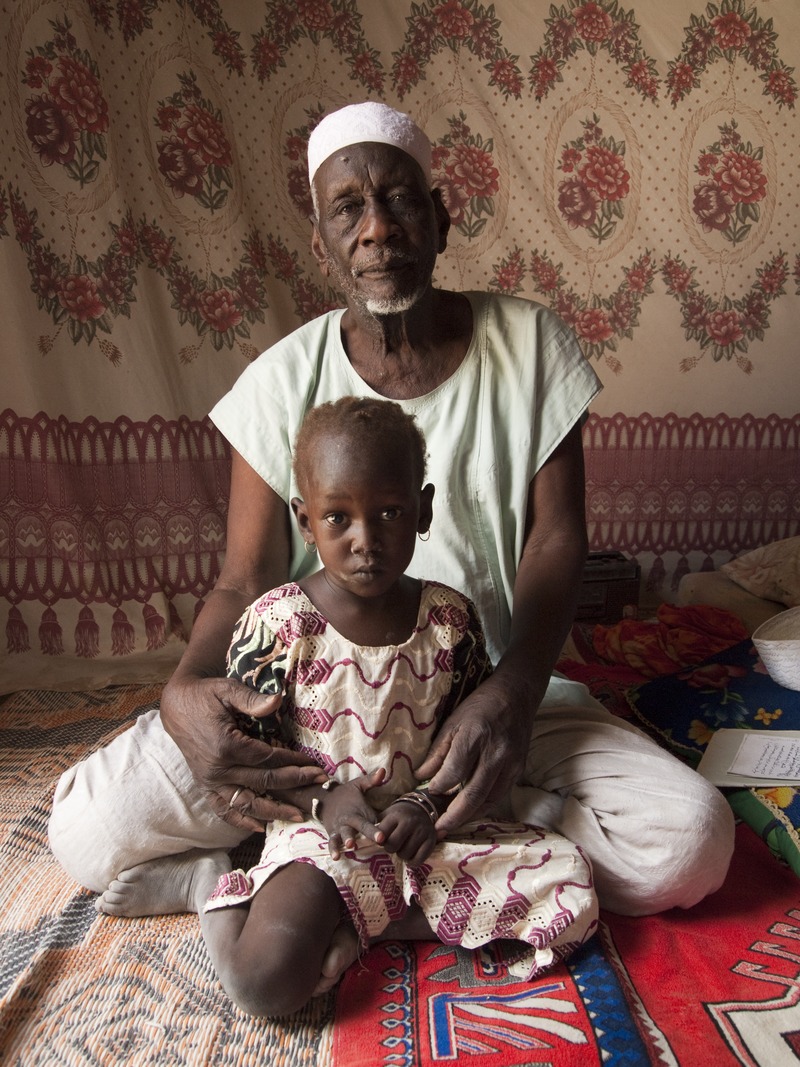[Imam Kura Nguigmibe, seated, with child]