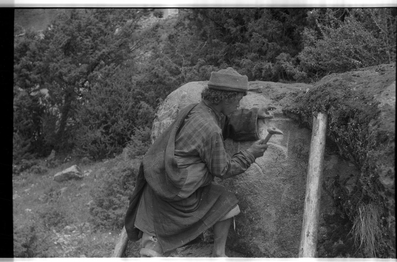 Man engraving a mani rock - 