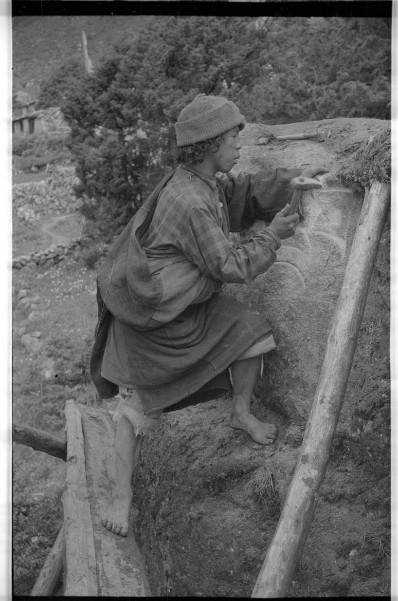 Man engraving a mani rock - 