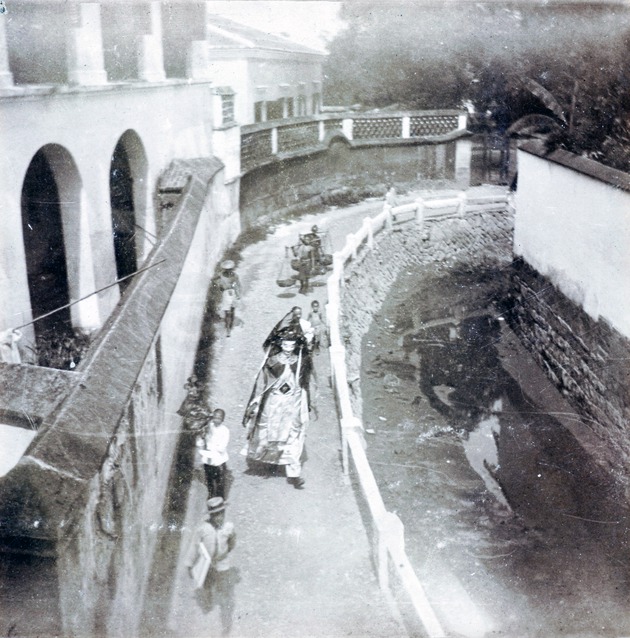 Photograph, view from an upper storey of a man dressed as a giant