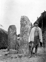 Man standing beside two monoliths at Nenglo (Image number U.042, J.P. Mills Photographic Collection)